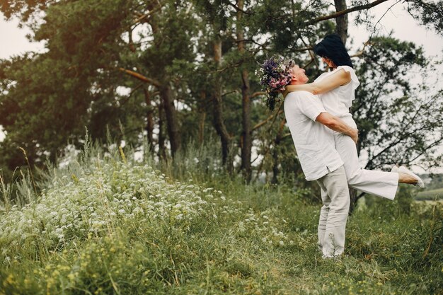 Hermosa pareja adulta pasa tiempo en un campo de verano