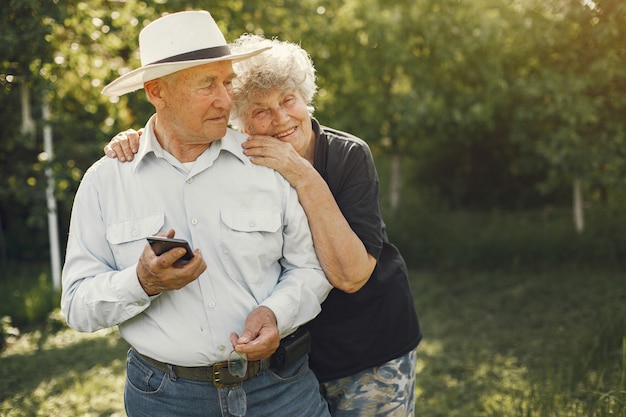 Foto gratuita hermosa pareja de ancianos pasar tiempo en un jardín de verano