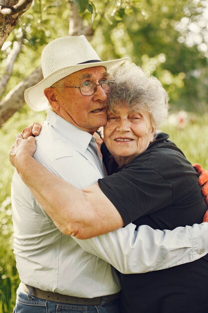 Hermosa pareja de ancianos pasar tiempo en un jardín de verano