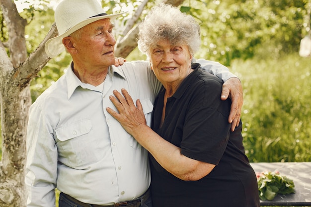 Hermosa pareja de ancianos pasar tiempo en un jardín de verano