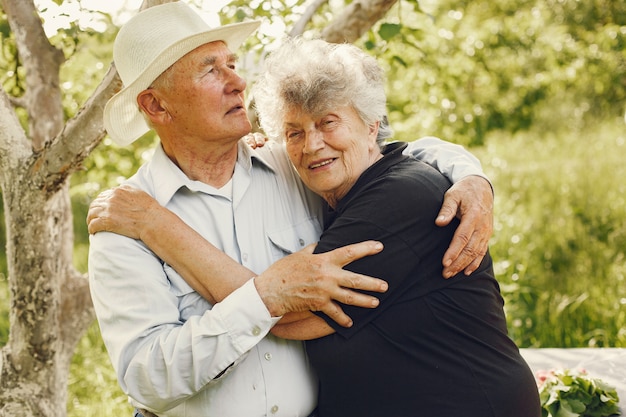 Hermosa pareja de ancianos pasar tiempo en un jardín de verano