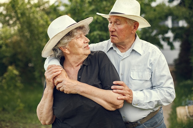 Hermosa pareja de ancianos pasar tiempo en un jardín de verano