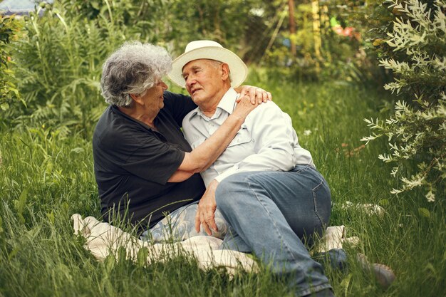 Hermosa pareja de ancianos pasar tiempo en un jardín de verano