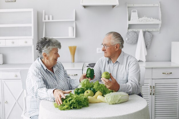 Hermosa pareja de ancianos prepara la comida en la cocina