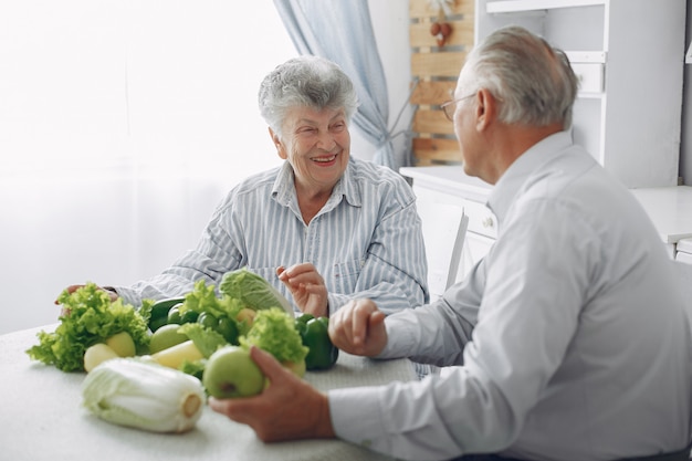 Hermosa pareja de ancianos prepara la comida en la cocina