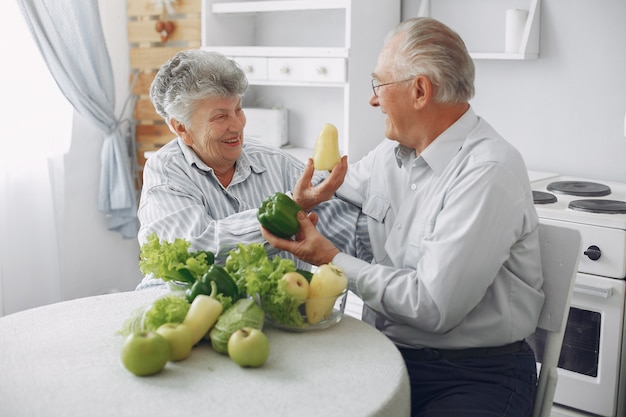 Hermosa pareja de ancianos prepara la comida en la cocina