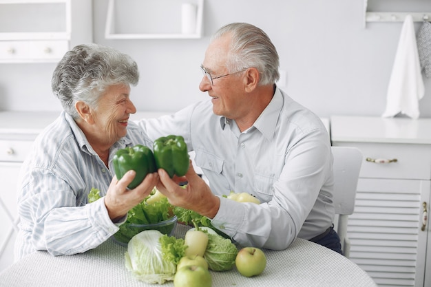 Hermosa pareja de ancianos prepara la comida en la cocina