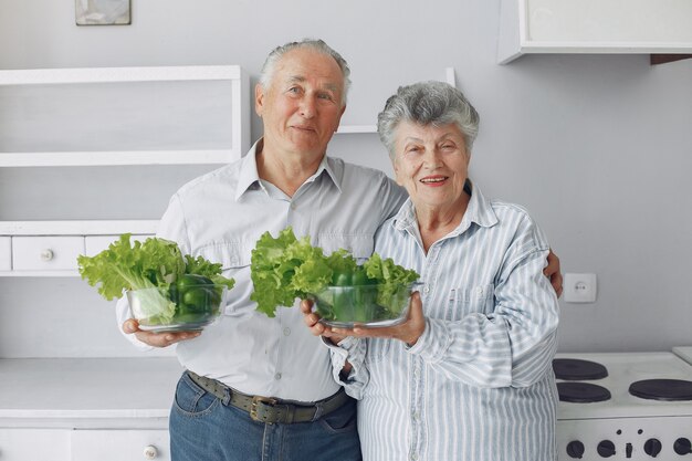 Hermosa pareja de ancianos prepara la comida en la cocina