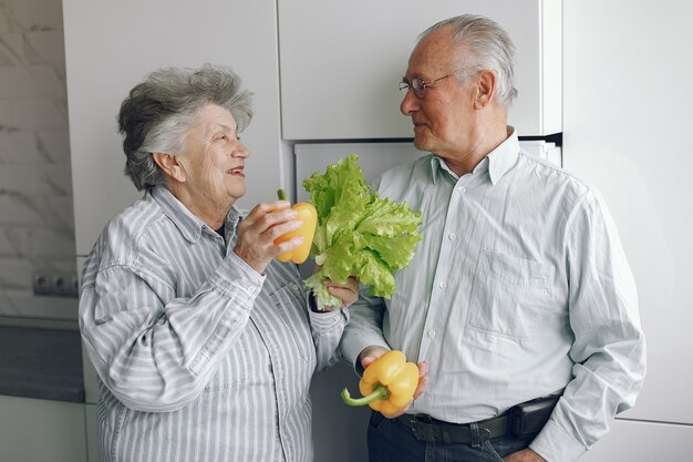 Hermosa pareja de ancianos prepara la comida en la cocina