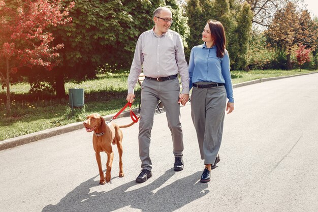 Hermosa pareja en un bosque de verano con perros