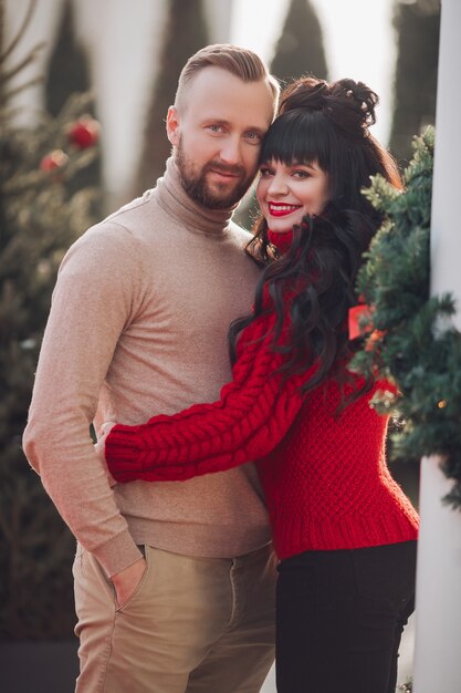 Hermosa pareja caucásica de enamorados abrazos juntos en la calle en Nochebuena