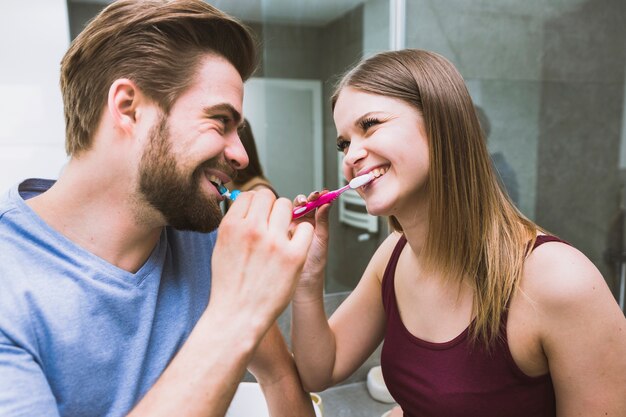 Hermosa pareja cepillarse los dientes