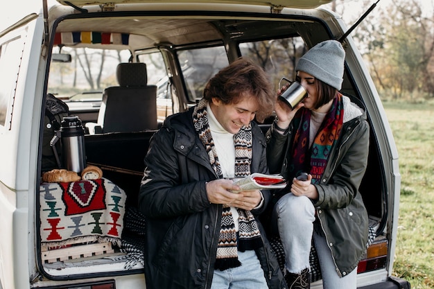 Hermosa pareja comprobar un mapa durante un viaje por carretera