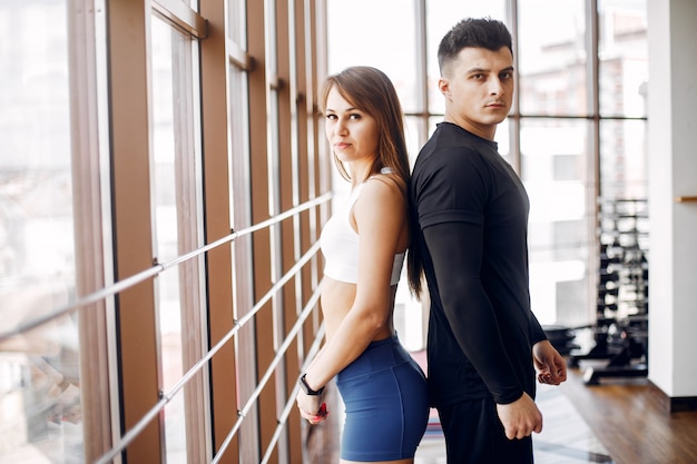 Una hermosa pareja de deportes se dedica a un gimnasio.