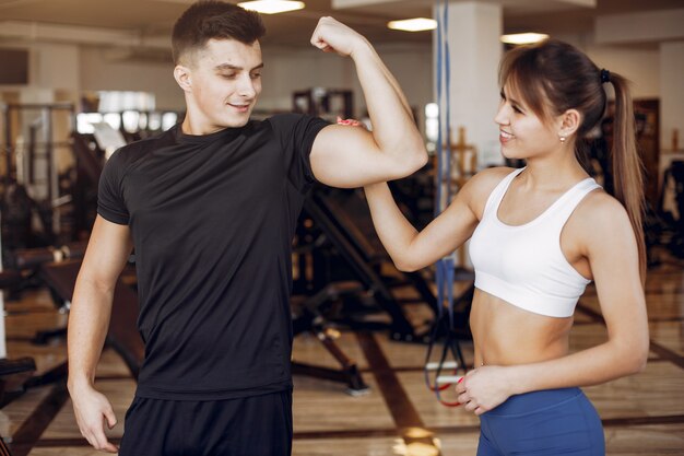 Una hermosa pareja de deportes se dedica a un gimnasio.