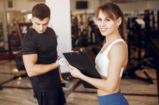 Una hermosa pareja de deportes se dedica a un gimnasio.