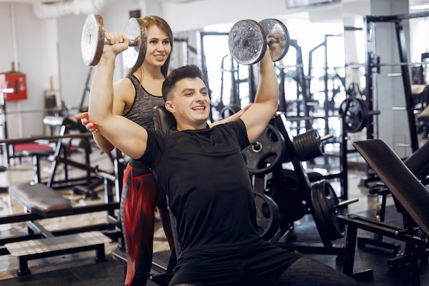 Una hermosa pareja de deportes se dedica a un gimnasio.