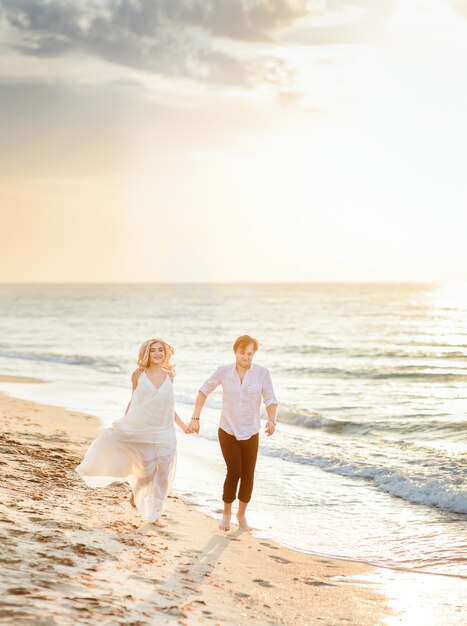 Hermosa pareja elegante caminando en la playa