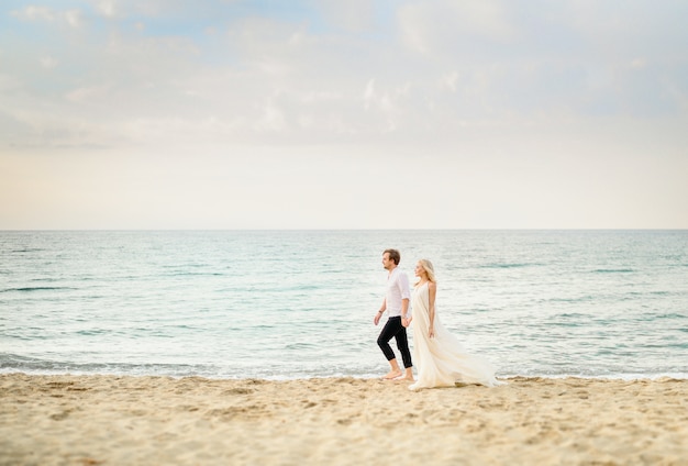 Hermosa pareja elegante posando en la playa