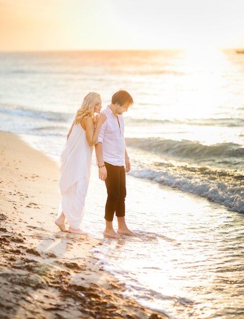 Hermosa pareja elegante posando en la playa