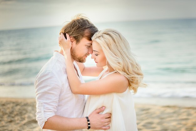 Hermosa pareja elegante posando en la playa