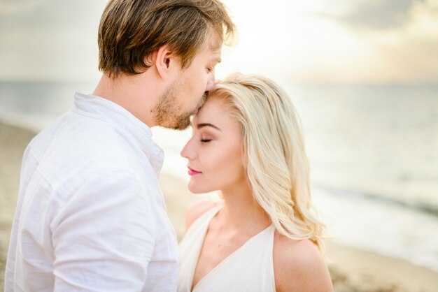 Hermosa pareja elegante posando en la playa