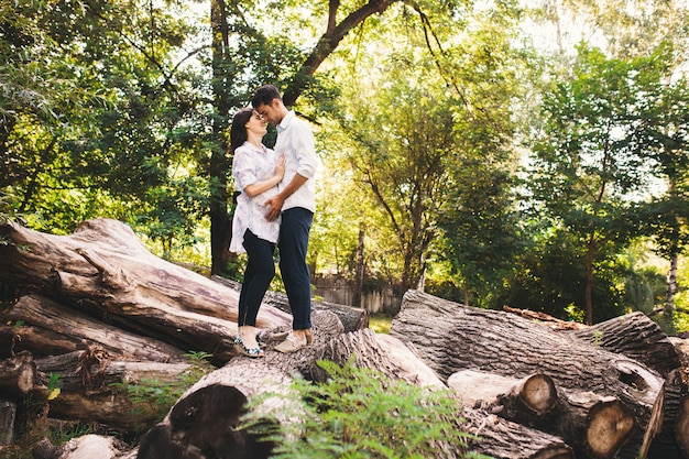 Foto gratuita hermosa pareja embarazada relajante afuera en el bosque