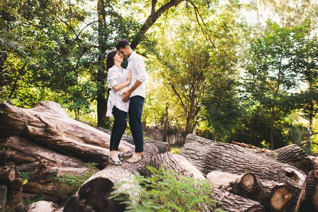 Hermosa pareja embarazada relajante afuera en el bosque