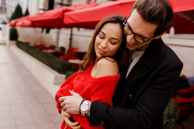 Foto gratuita hermosa pareja de enamorados abrazándose y coqueteando al aire libre. momentos románticos. hombre guapo mirando a su novia bonita.