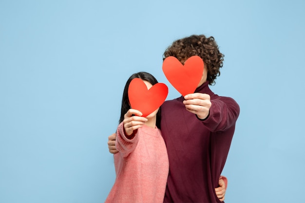 Hermosa pareja de enamorados en la pared azul del estudio