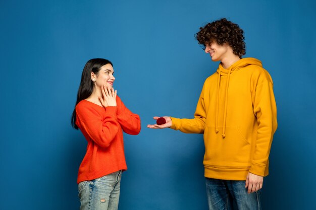 Hermosa pareja de enamorados en la pared azul del estudio