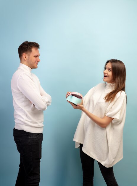 Hermosa pareja de enamorados en la pared azul del estudio