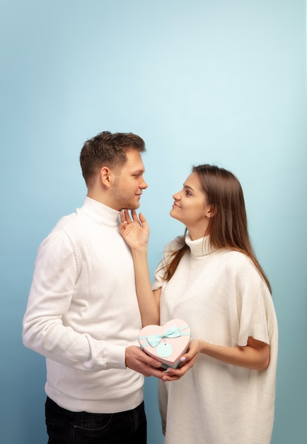 Hermosa pareja de enamorados en la pared azul del estudio