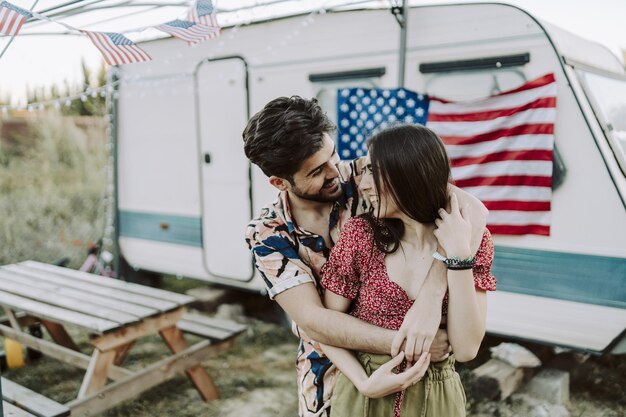 Hermosa pareja española abrazándose en la bandera estadounidense