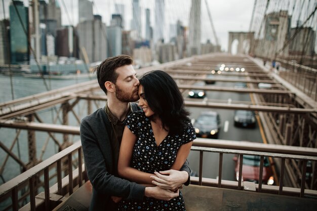 Hermosa pareja de hombre americano con barba y tierna mujer oriental se abrazan