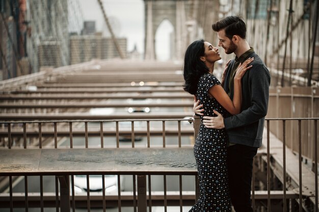 Hermosa pareja de hombre americano con barba y tierna mujer oriental se abrazan