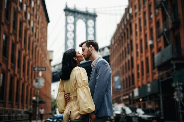 Hermosa pareja de hombre americano con barba y tierna mujer oriental se abrazan