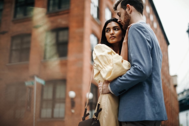 Hermosa pareja de hombre americano con barba y tierna mujer oriental se abrazan