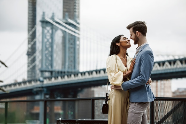 Hermosa pareja de hombre americano con barba y tierna mujer oriental se abrazan