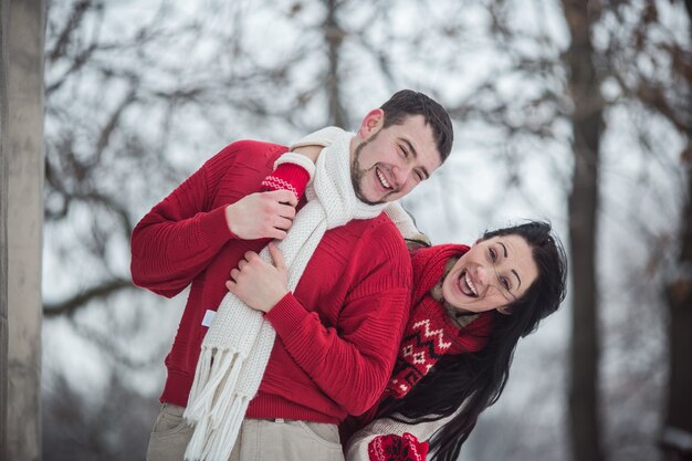 Hermosa pareja joven en el bosque de invierno