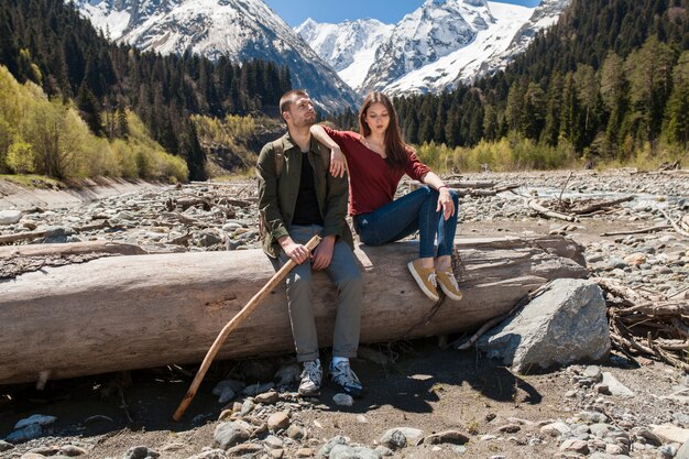 Hermosa pareja joven inconformista senderismo en el río en el bosque