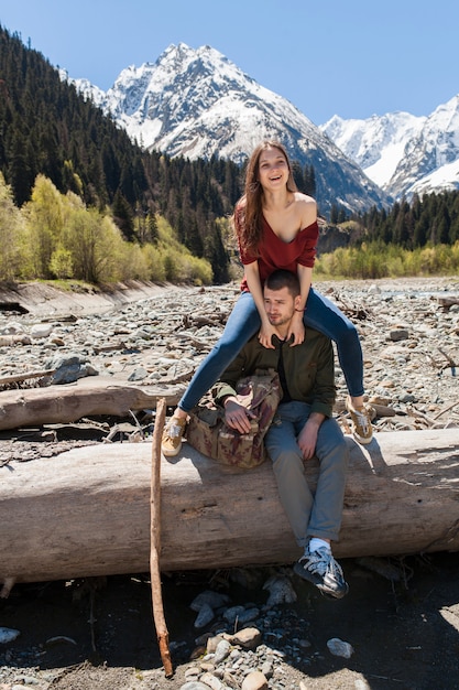 Hermosa pareja joven inconformista senderismo en el río en el bosque