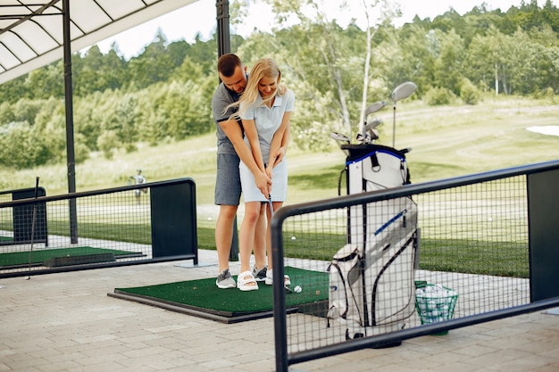 Hermosa pareja jugando al golf en un campo de golf