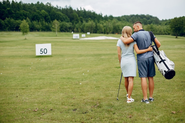 Hermosa pareja jugando al golf en un campo de golf