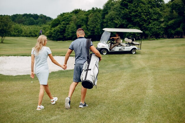 Hermosa pareja jugando al golf en un campo de golf