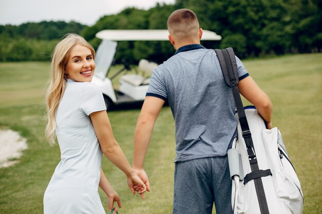 Hermosa pareja jugando al golf en un campo de golf