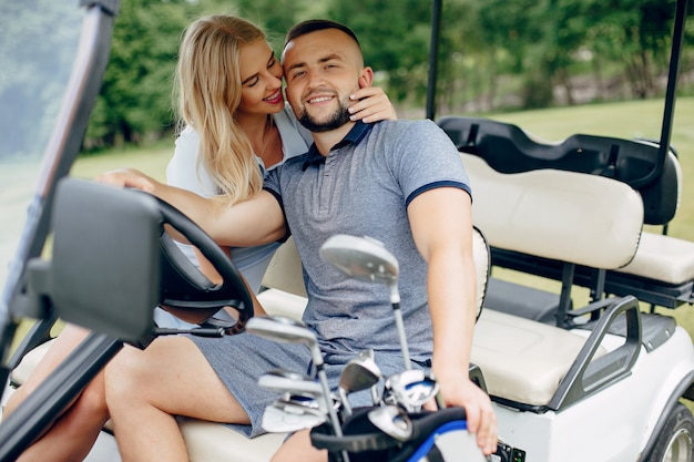 Hermosa pareja jugando al golf en un campo de golf