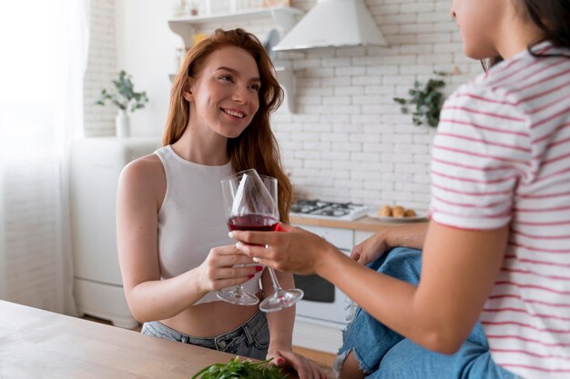 Hermosa pareja de lesbianas animando con unas copas de vino