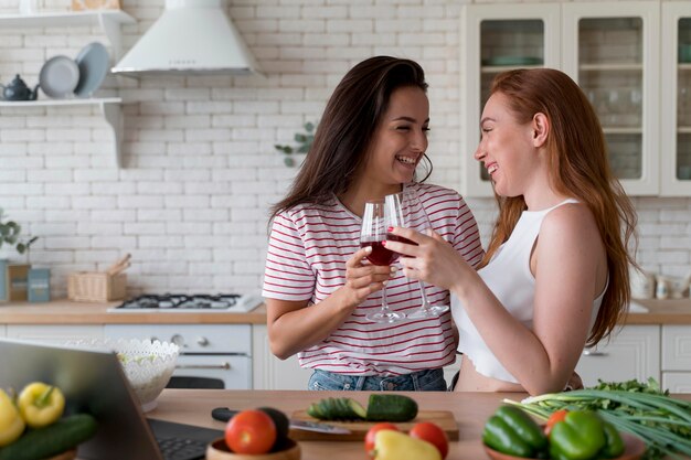 Hermosa pareja de lesbianas animando con unas copas de vino