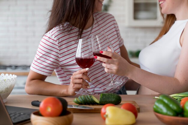 Hermosa pareja de lesbianas animando con unas copas de vino